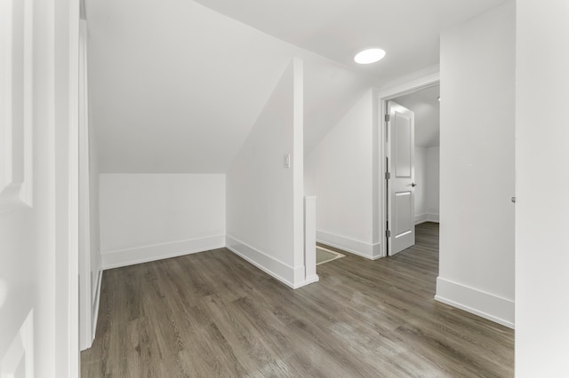 bonus room with dark wood-type flooring and vaulted ceiling