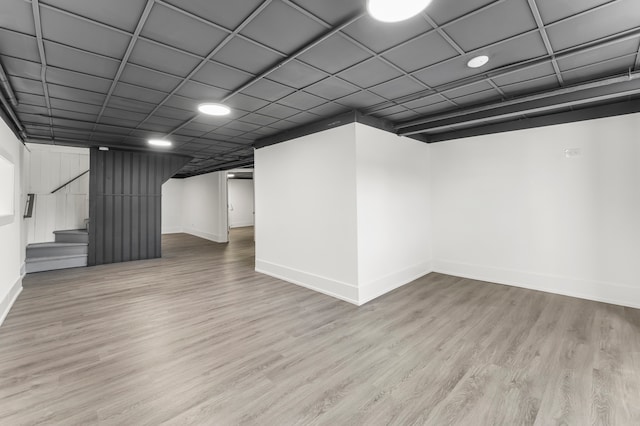 basement with light wood-type flooring and a drop ceiling