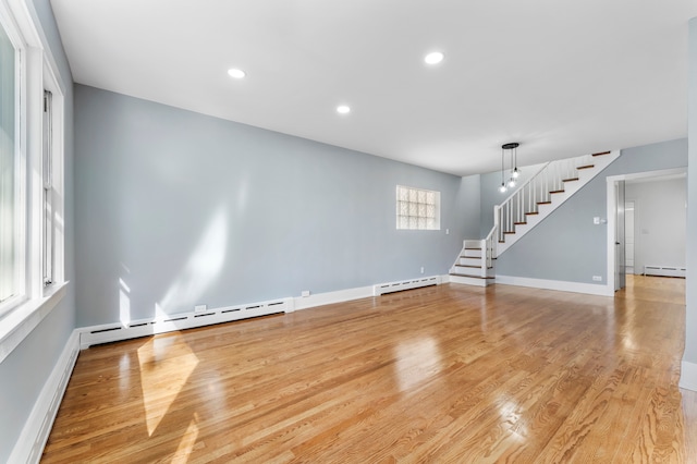 unfurnished room featuring a chandelier, light hardwood / wood-style floors, and a baseboard heating unit