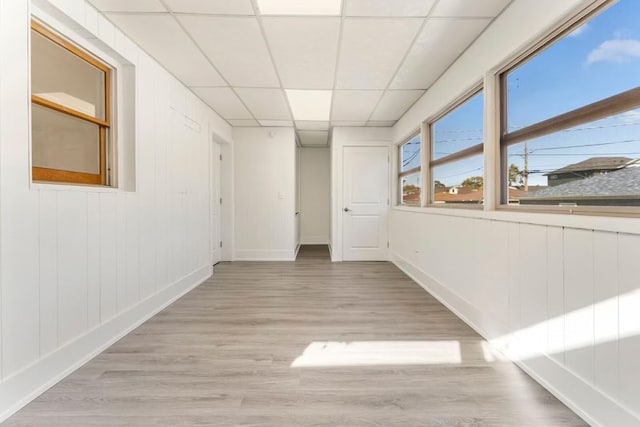 unfurnished room featuring a drop ceiling and light hardwood / wood-style flooring