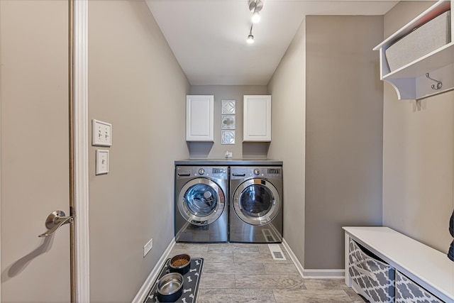 laundry area featuring washer and dryer and cabinets