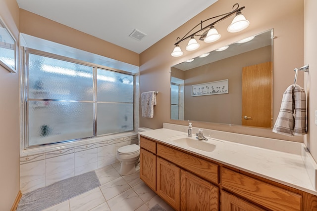 full bathroom featuring vanity, toilet, and bath / shower combo with glass door