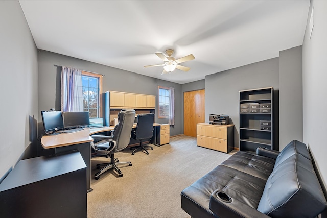 carpeted office space with a wealth of natural light and ceiling fan