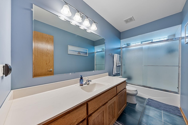 full bathroom featuring tile patterned flooring, toilet, combined bath / shower with glass door, and vanity