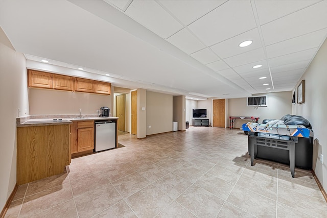 interior space featuring a paneled ceiling, sink, light tile patterned flooring, and stainless steel dishwasher