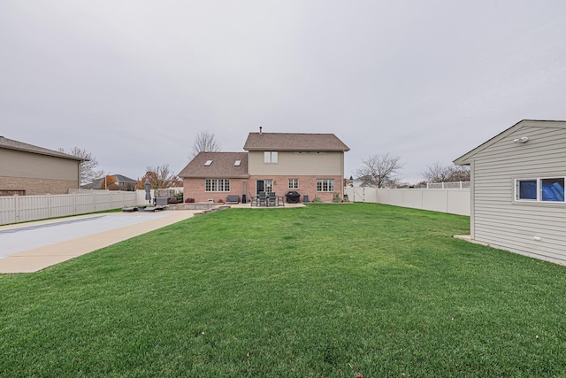 rear view of house featuring a yard and a patio