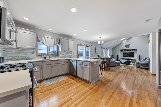 kitchen featuring kitchen peninsula, a breakfast bar, decorative light fixtures, and light hardwood / wood-style flooring