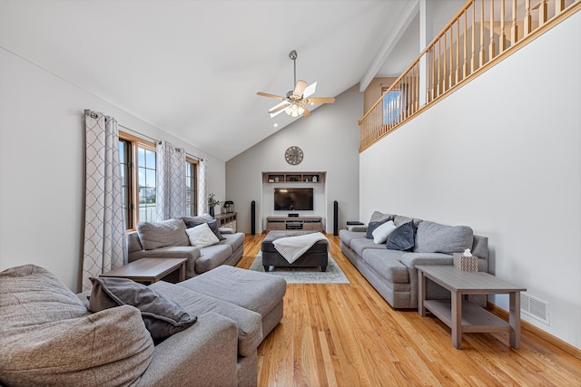 living room featuring hardwood / wood-style floors, ceiling fan, and high vaulted ceiling