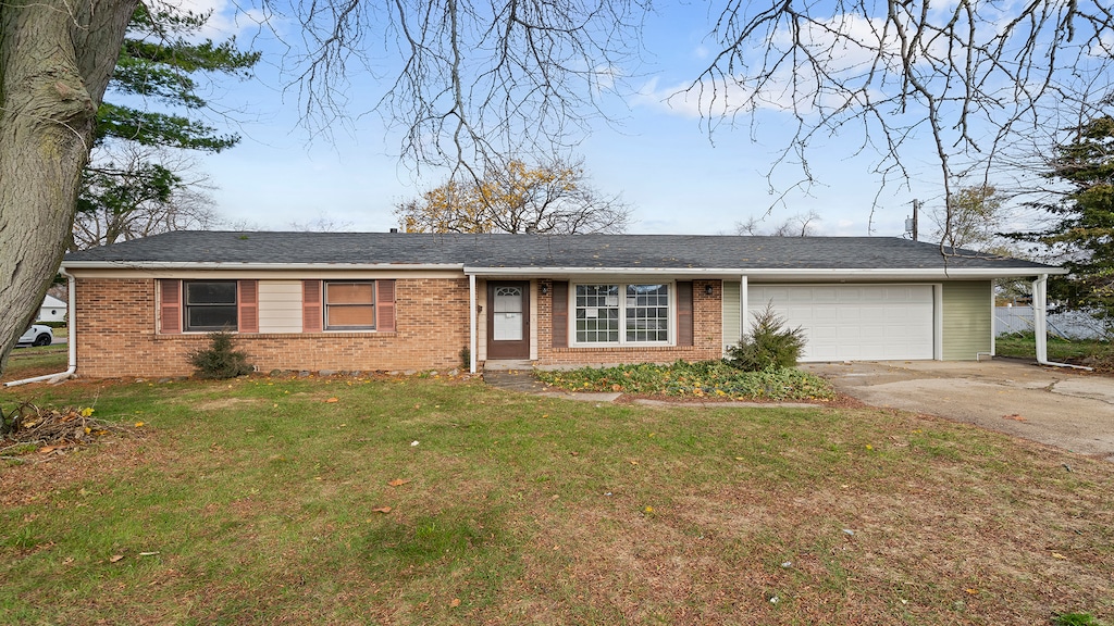 ranch-style house with a garage and a front lawn