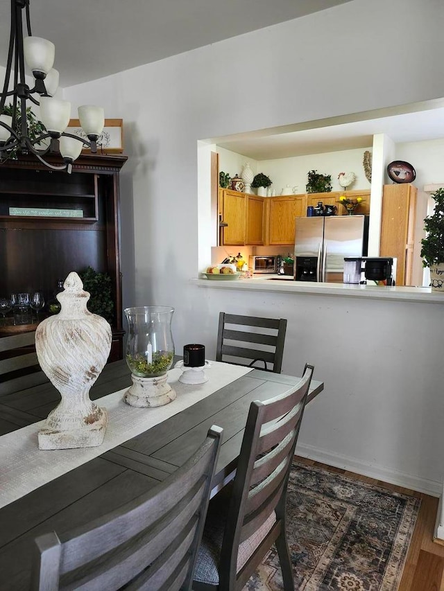 dining room with a notable chandelier and dark hardwood / wood-style floors