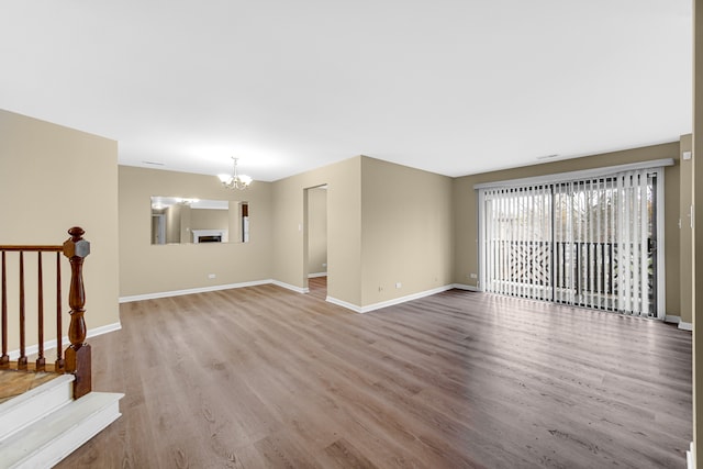 unfurnished living room with light hardwood / wood-style floors and a notable chandelier