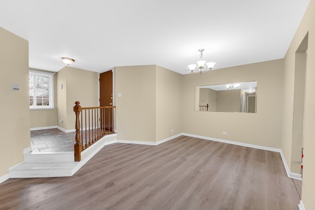 spare room featuring light hardwood / wood-style floors and an inviting chandelier