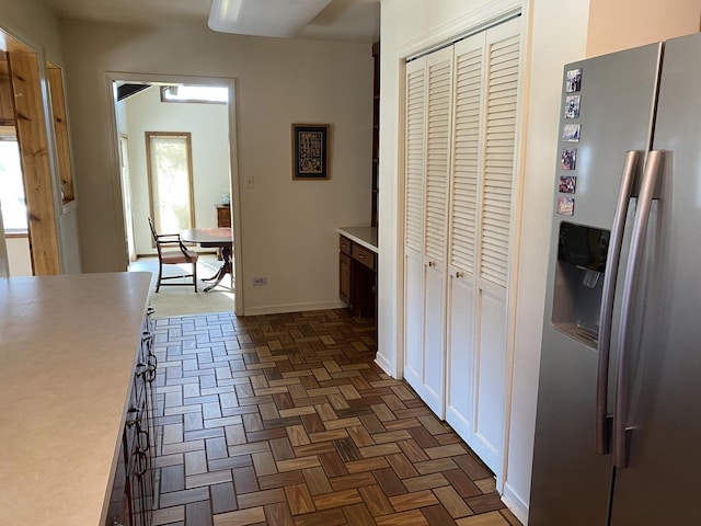 kitchen with white cabinets, stainless steel fridge with ice dispenser, and dark parquet floors