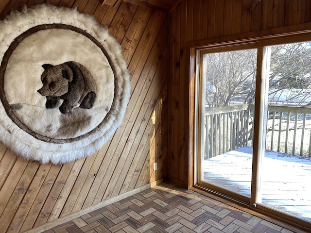 entryway with parquet floors and wood walls