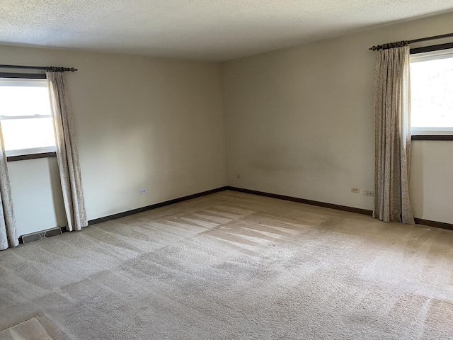 carpeted empty room with a textured ceiling