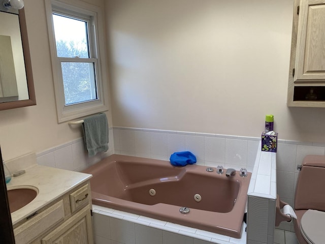 bathroom with a tub to relax in, vanity, and toilet