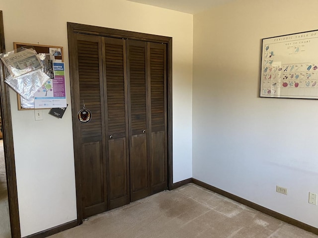 unfurnished bedroom featuring a closet and light colored carpet