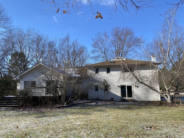 back of house featuring a lawn and a wooden deck