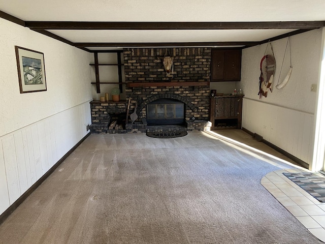 unfurnished living room with carpet, beam ceiling, and a brick fireplace