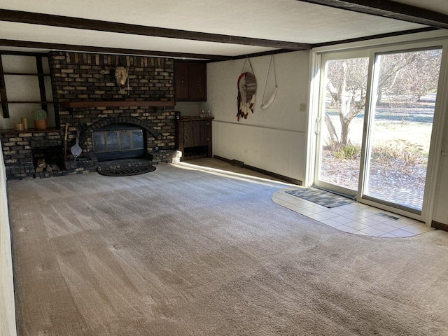 unfurnished living room with a fireplace, beam ceiling, and light carpet