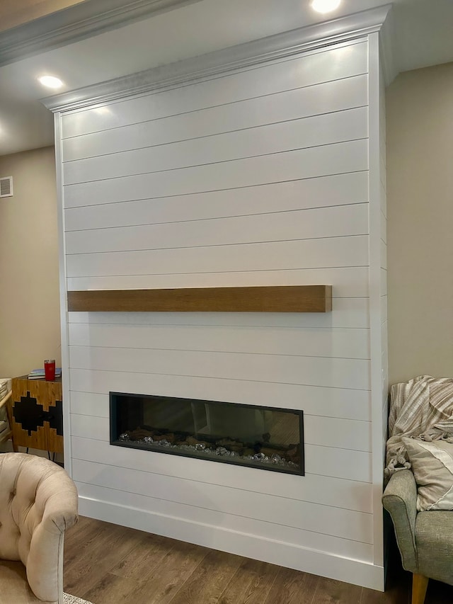 interior details with hardwood / wood-style floors, ornamental molding, and a fireplace