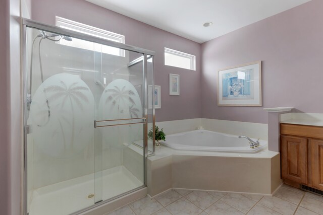 bathroom with tile patterned flooring, vanity, and separate shower and tub