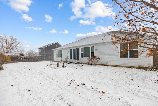 view of snow covered back of property