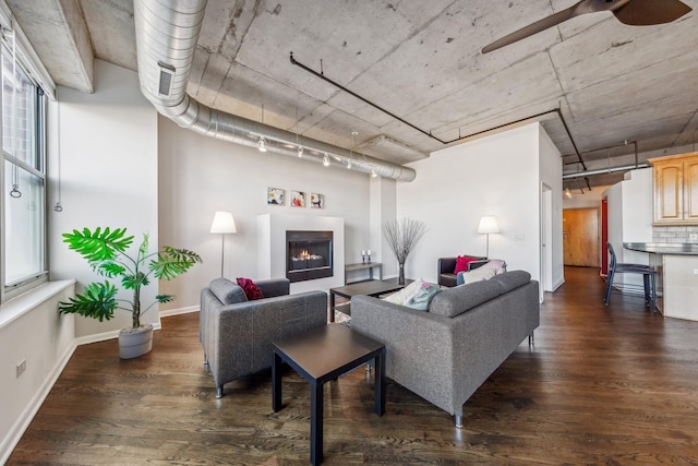 living room with ceiling fan and dark hardwood / wood-style flooring