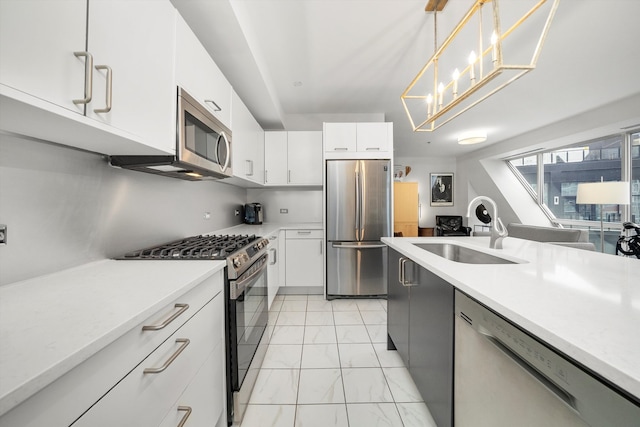 kitchen featuring sink, hanging light fixtures, an inviting chandelier, white cabinets, and appliances with stainless steel finishes