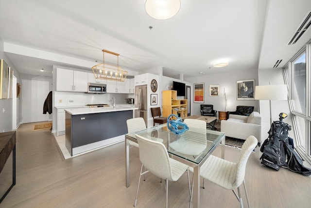 dining area with light wood-type flooring and sink