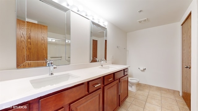 bathroom with tile patterned flooring, vanity, and toilet