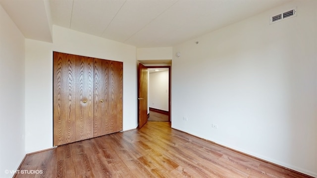 unfurnished bedroom featuring light hardwood / wood-style flooring and a closet