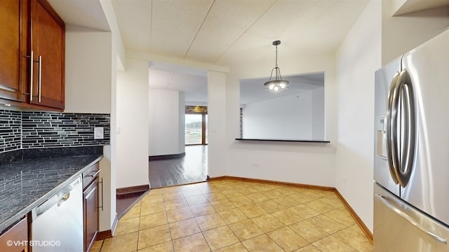 kitchen featuring decorative backsplash, light tile patterned floors, decorative light fixtures, and appliances with stainless steel finishes