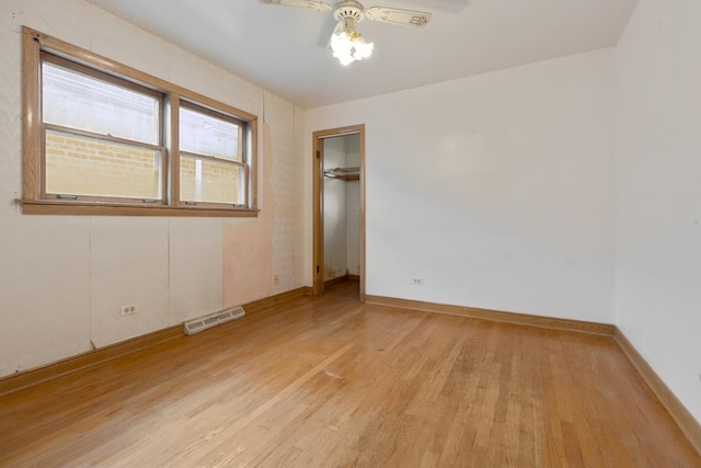 empty room with ceiling fan and light hardwood / wood-style floors