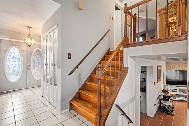 tiled foyer entrance featuring french doors and an inviting chandelier