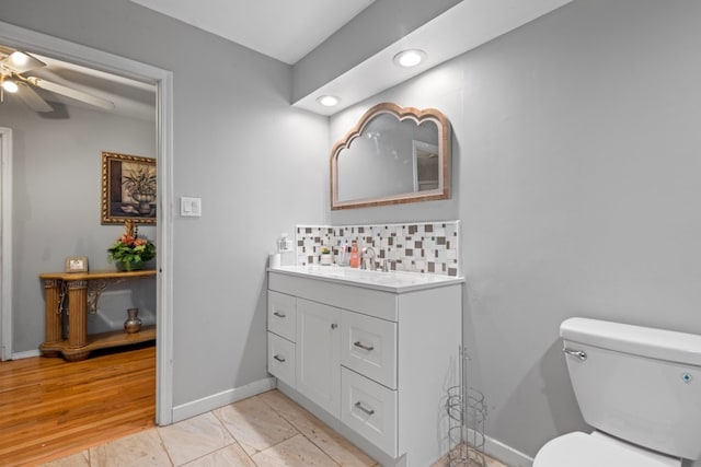 bathroom featuring backsplash, tile patterned floors, vanity, ceiling fan, and toilet