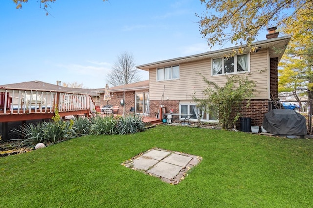 back of property with a yard and a wooden deck