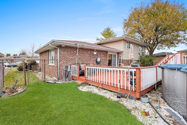 rear view of property with a swimming pool side deck and a lawn