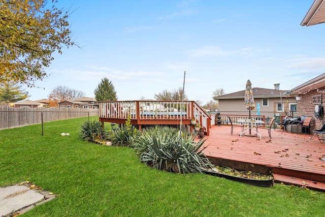 wooden deck featuring a lawn