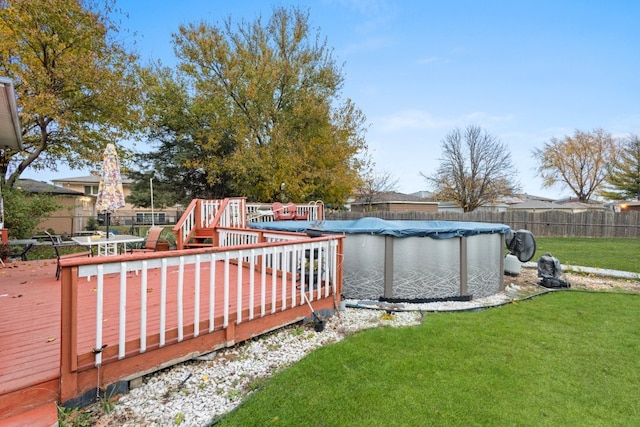 wooden terrace featuring a yard and a covered pool