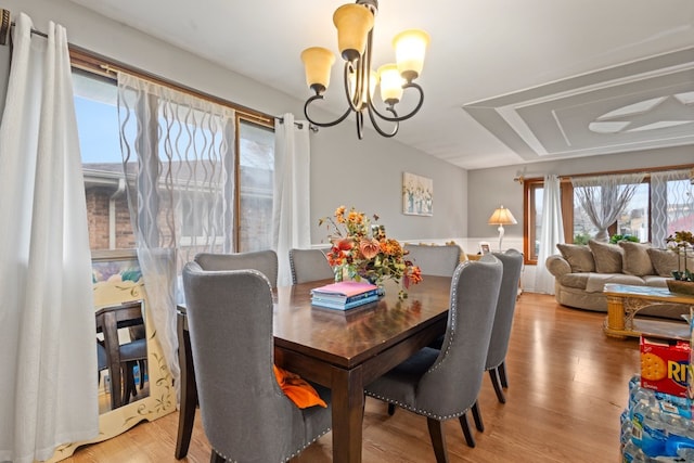 dining space featuring light hardwood / wood-style flooring and an inviting chandelier