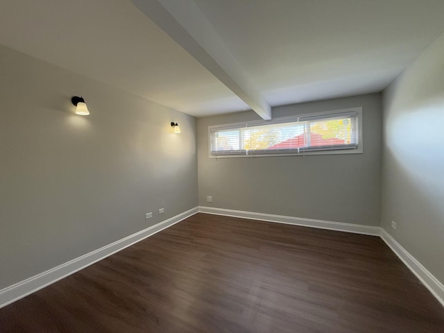 empty room with beamed ceiling and dark hardwood / wood-style floors