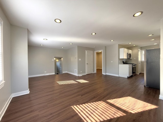 unfurnished living room with dark hardwood / wood-style floors and a wealth of natural light