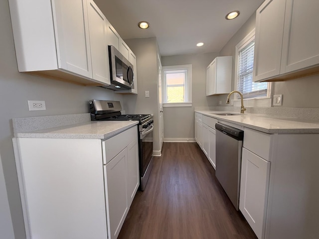 kitchen featuring dark hardwood / wood-style floors, sink, white cabinetry, and stainless steel appliances