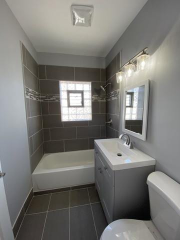 full bathroom featuring toilet, tiled shower / bath, and a wealth of natural light