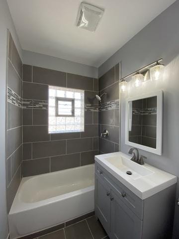 bathroom featuring tile patterned flooring, vanity, and tiled shower / bath