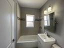 bathroom with vanity and a washtub