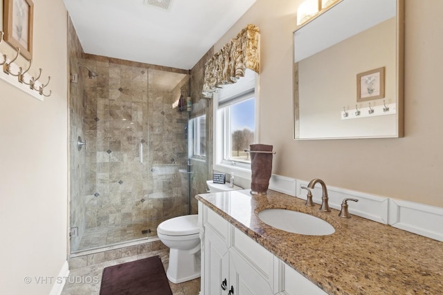 bathroom featuring vanity, toilet, and walk in shower