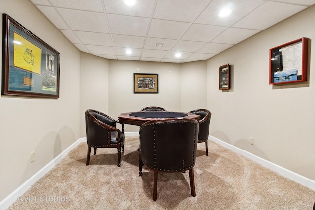 dining area featuring light carpet and a drop ceiling