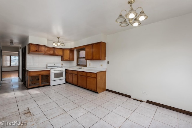 kitchen with sink, a chandelier, decorative backsplash, light tile patterned floors, and white gas range oven